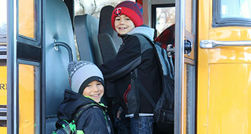 Kids waving out the school bus windows