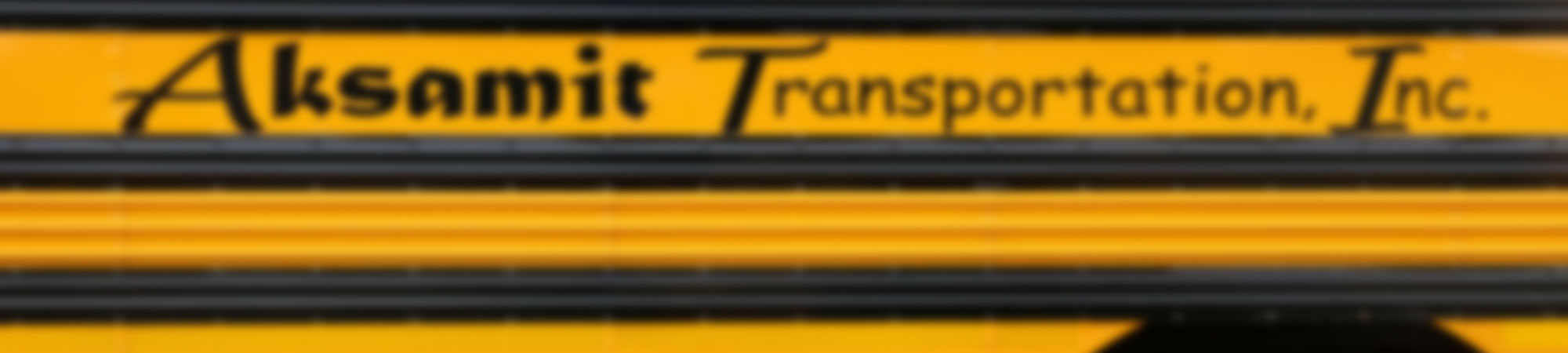 Blurred photo of the side of a yellow bus with the words School Bus across the side